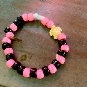 Pink and black, medium, leaves charms and turtle charm and white cross charm